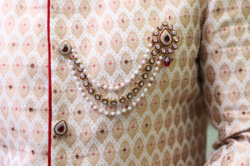 Closeup of a brooch on a Sherwan of an Indian groom during the wedding ceremony - obrazy, fototapety, plakaty