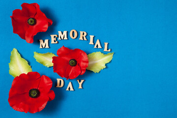 Text Memorial Day and a poppy flowers on blue background