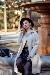 Young girl walks around in hat and coat