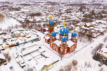 Scenic view from drone of Temple of Intercession of Holy Virgin with Petrovsk cityscape on background in winter, Russia.