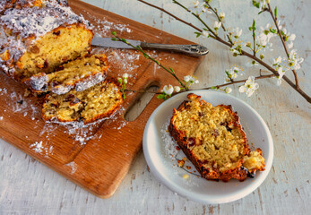 Homemade delicious muffin made from natural products lies on a wooden cutting board. Blooming cherry branches are reminiscent of spring. Vintage.