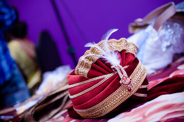 Closeup of a shiny red Turban on the table for an Indian wedding ceremony