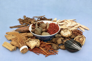 Chinese acupuncture needles with herbs and spice used in traditional herbal medicine and treatment  on mottled blue background. Alternative and natural health care concept.