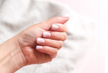 Gradient manicure and Hands Spa. Beautiful Woman hand closeup. Manicured nails and Soft hands skin. Beautiful woman's nails with beautiful baby boomer manicure, pink background. Copy space  - obrazy, fototapety, plakaty