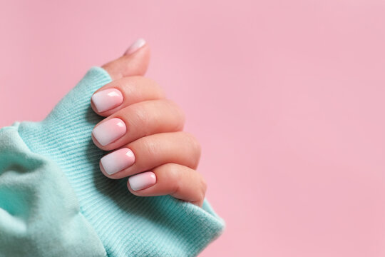 Gradient manicure and Hands Spa. Beautiful Woman hand closeup. Manicured nails and Soft hands skin. Beautiful woman's nails with beautiful baby boomer manicure, pink background. Copy space 