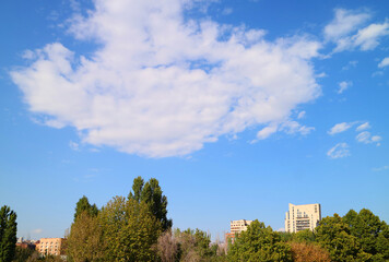 White clouds floating on sunny blue sky over the city