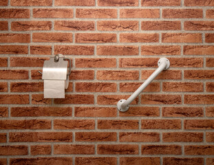 Bathroom detail. Toalet paper holder and handrail on a brick-shaped wall - obrazy, fototapety, plakaty