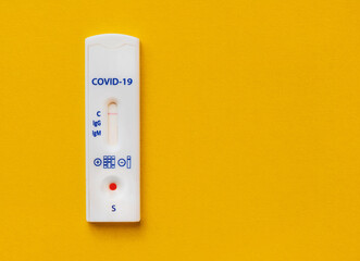 coronavirus covid test on a yellow, bright background. medical analysis. test strip to assess the presence of IgG and IgM antibodies. girl with red manicure adds saline to the strip