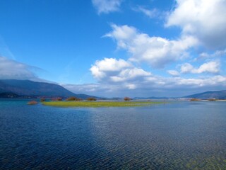 Scenic view of beautiful lake Cerknica or Cerknisko jezero in Notranjska region of Slovenia with white clouds in blue sky