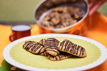Butter cookies with chocolate on top on yellow tray ready to eat. Concept of homemade food.