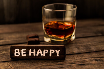 Glass of brandy with chocolate and the wooden plank on it is an inscription 