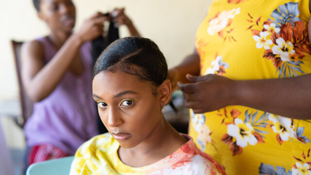 Young black girl getting hair braided