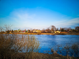 View of small Russian village on the river bank. Spring landscape.