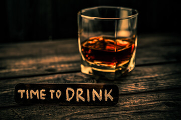 Glass of brandy with the wooden plank on it is an inscription 