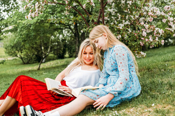 Mom and daughter walking in the park, reading books, socializing, laughter and fun, entertainment, hobbies