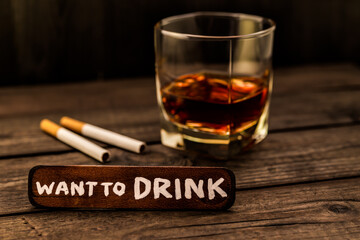 Glass of brandy with cigarettes and the wooden plank on it is an inscription 