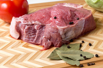 Fresh pork fillet, bay leaf and pepper on a cutting board. Pork meat. Protein product. Healthy diet. High quality photo