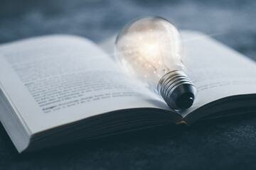 Book or textbook with glowing light bulb. Self learning or education knowledge and business studying concept. Idea of learning or studying at home