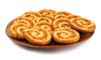 Obraz na płótnie Canvas A clay plate with cookies is isolated on a white background. Cookies with a beautiful spiral pattern.