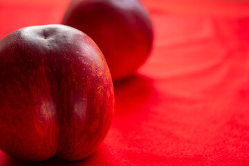 Nectarine on a red background.Vitamin nectarine is a delicious and sweet fruit.