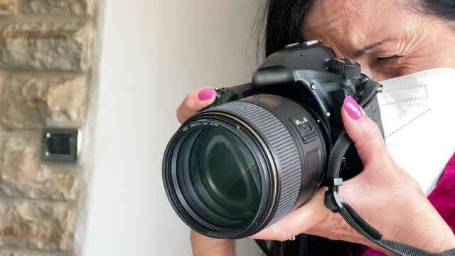 Female photographer taking images of house interior detail with long lens