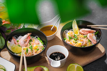 rice noodles. asian rice noodles in black plates with seafood and vegetables.