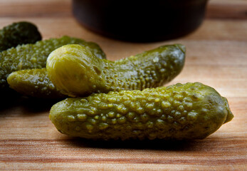 Juicy pickled cucumbers on a wooden cutting board. Salted cucumbers.