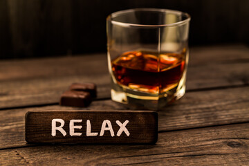 Glass of brandy with chocolate and the wooden plank on it is an inscription 