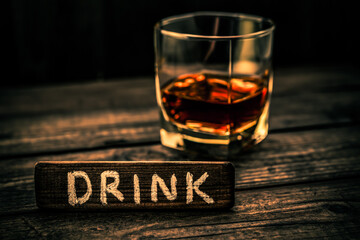 Glass of brandy with the wooden plank on it is an inscription 