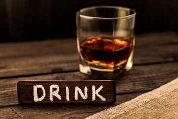 Glass of brandy with a piece of canvas and the wooden plank on it is an inscription 