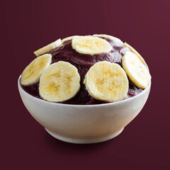 Açai, Brazilian frozen açai berry ice cream bowl with banana slices.  Isolated on purple background