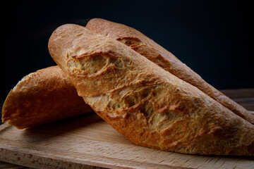 Sliced fresh crispy baguette on a wooden cutting board. art bread.