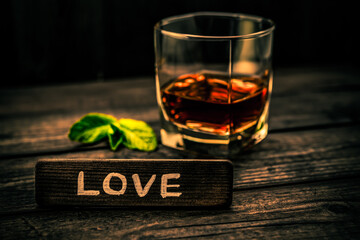 Glass of brandy with mint sprig and the wooden plank on it is an inscription 