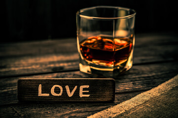 Glass of brandy with a piece of canvas and the wooden plank on it is an inscription 