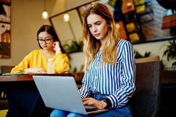 Young students doing homework in cafe