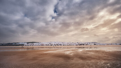 Panoramic view of the city of Conil seen from the beach and with a sky with gray clouds
