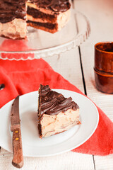 Dark chocolate cake with Coffee slice with chocolate buttercream frosting on a white plate.Selective focus