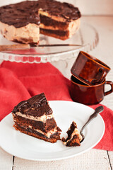 Dark chocolate cake with Coffee slice with chocolate buttercream frosting on a white plate.Selective focus