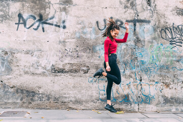 Young woman outdoors jumping dancing