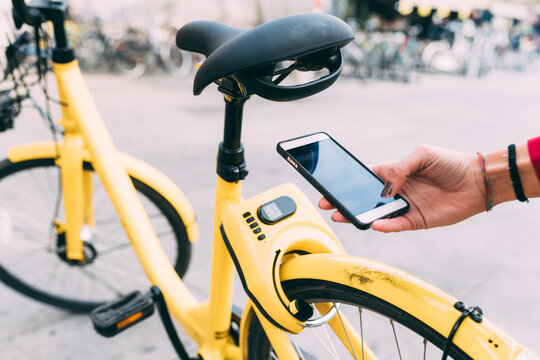 Close up woman hand using smartphone unlocking bike sharing