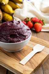 Açai, Brazilian frozen açai berry ice cream bowl. with fruits on wooden background. Summer menu front view