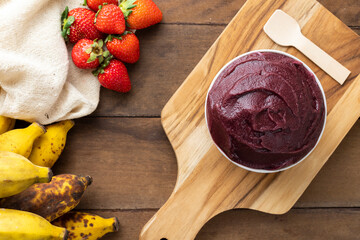 Açai, Brazilian frozen açai berry ice cream bowl. with fruits on wooden background. Summer menu top view