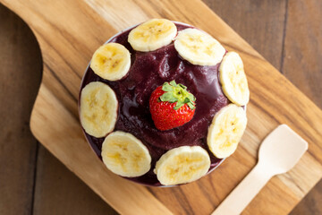 Açai, Brazilian frozen açai berry ice cream bowl. with fruits on wooden background. Summer menu top view