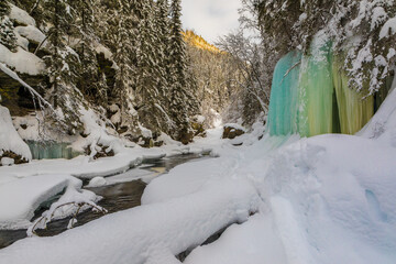 winter in the forest with river and cave