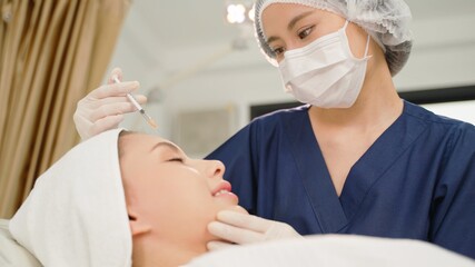 Beauty clinic. Beautician hands in gloves making face aging injection in a female skin. A woman gets beauty facial cosmetology procedure. Botox. collagen injections.