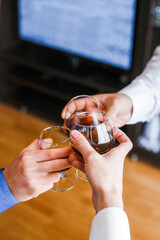 three men clink glasses with alcohol