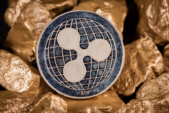 Ripple XRP cryptocurrency with gold nuggets. Investment and store of value concept. Slovenia, Ljubljana - 21 April 2021
