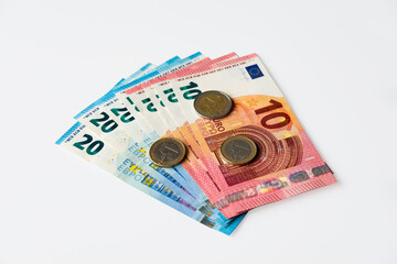 10 and 20 euro banknotes and euro coins isolated on white background.