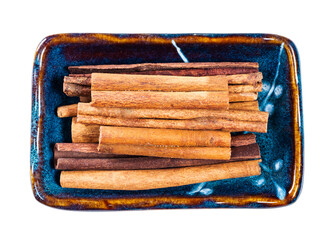 sticks of cassia cinnamon in ceramic bowl cutout