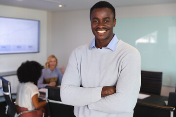 Portrait of african american man smiling while standing in the meeting room at modern office